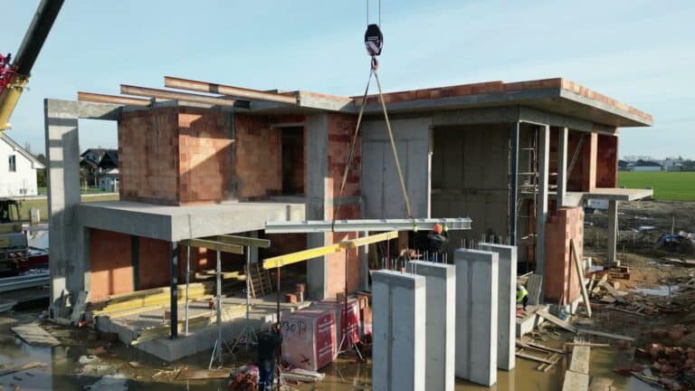 Montaż prefabrykowanych elementów betonowych przy budowie domu piętrowego