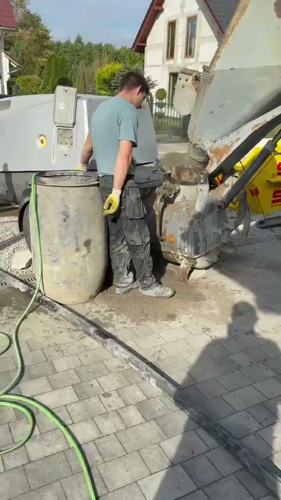 Pracownik przy betonomieszarce podczas przygotowania mieszanki betonowej